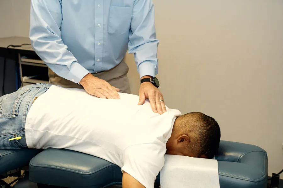 Dr. James Yager performing a hands-on chiropractic adjustment on a patient